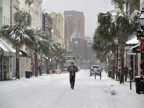 A person walks in the snow on King Street in Charleston, S.C., Wednesday, Jan. 3, 2018. (Matthew Fortner/The Post And Courier via AP)