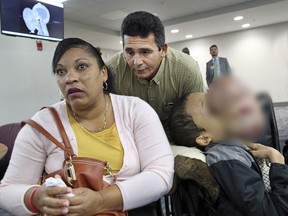 In this Jan. 12, 2018, file photo, Emanuel Zayas sits with his parents Noel Zayas and Melvis Vizcaino at Holtz Children's Hospital at Jackson Memorial in Miami.