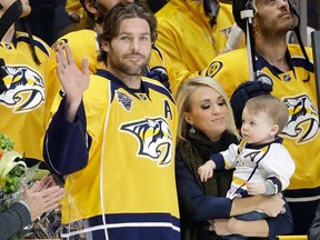 In this March 21, 2016, file photo, Nashville Predators forward Mike Fisher is honored for his 1,000th NHL hockey game before the first period of a game against the Los Angeles Kings, in Nashville, Tenn.