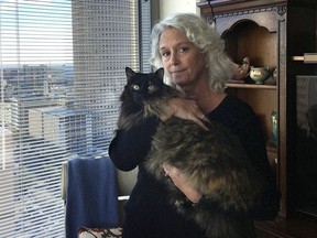 Christine Lee holds her long-haired house cat, Calli, in her condominium in downtown Tampa, Fla., on Thursday, Jan. 4, 2017. In a lawsuit, a contractor alleges that he was attacked by a bobcat while working in the condo.