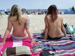 In this Aug. 26, 2017 photo, women go topless as they participate in the Free the Nipple global movement during Go Topless Day at Hampton Beach, N.H.