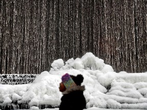 Alora Freeman, 8, watches as ice builds along a downtown water fountain in Atlanta, Wednesday, Jan. 3, 2018. A brutal winter storm scattered a wintry mix of snow, sleet and freezing rain from normally balmy north Florida up the Southeast seaboard Wednesday, adding to the misery of a bitter cold snap. Georgia Gov. Nathan Deal declared a state of emergency through Friday for at least 28 counties because of the frigid weather.