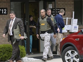 In this April 21, 2017 file photo, FBI agents leave the office of Dr. Fakhruddin Attar at the Burhani Clinic in Livonia, Mich., after completing a search for documents.