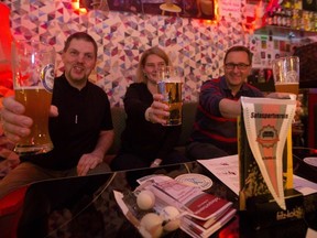 In this Jan. 11, 2018 photo from left: Torben Bertram, Patricia Bernreuther and Norbert Buddendick hold a glas of beer during a training session of Germany's first sofa sports association at the 'Radio - The Label Bar' in Berlin.