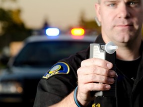 This stock photo shows a police officer holding breath test machine at a traffic stop.
