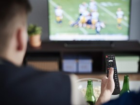 In this stock photo, a couple watches a football game on their television.