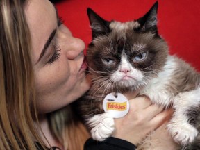 In this Nov. 14, 2016 file photo, Grumpy Cat poses for photos with her owner, Tabatha Bundesen, in New York.