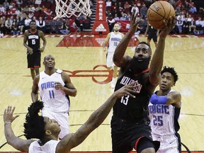 Orlando Magic guard Mario Hezonja (8) drives to the basket past Houston Rockets guard Eric Gordon during the first half of an NBA basketball game Tuesday, Jan. 30, 2018, in Houston.