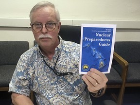 In this July 21, 2017, file photo, Toby Clairmont, the Hawaii Emergency Management Agency's executive officer, shows new informational materials to a reporter in Honolulu. (AP Photo/Jennifer Sinco Kelleher, File)