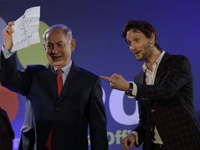 In this photo dated Wednesday, Jan. 10, 2018, Israeli mentalist Lior Suchard, right, gestures as he stands with Israeli Prime Minister Benjamin Netanyahu during the annual toast with the foreign media in Jerusalem.