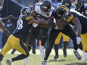 Jacksonville Jaguars running back Leonard Fournette is tackled by Pittsburgh Steelers strong safety Sean Davis (28) during the first half of an NFL divisional football AFC playoff game in Pittsburgh, Sunday, Jan. 14, 2018. (AP Photo/Don Wright)