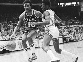 In this Dec. 30, 1977 file photo, Jo Jo White, left, of the Boston Celtics, drives past Chicago Bulls' Wilbur Holland (12) during an NBA game in Chicago. (AP Photo/Fred Jewell, File)