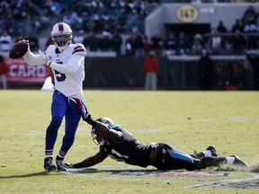 Jacksonville Jaguars defensive end Yannick Ngakoue, right, tries to stop Buffalo Bills quarterback Tyrod Taylor who scrambles from the pocket to throw a pass in the first half of an NFL wild-card playoff football game, Sunday, Jan. 7, 2018, in Jacksonville, Fla.