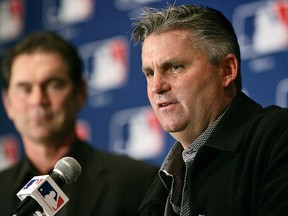In this Dec. 7, 2005, file photo, San Diego Padres general manager Kevin Towers, right, peaks during a news conference in Dallas. (AP Photo/Tony Gutierrez, File)