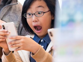 A girl reacts as she tries an iPhone X at the Apple Omotesando store on Nov. 3, 2017 in Tokyo, Japan. (Tomohiro Ohsumi/Getty Images)
