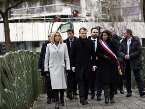 French President Emmanuel Macron, centre, his wife Brigitte, left, and Paris mayor Anne Hidalgo arrive to observe a minute of silence in front of the plaque commemorating late police officer Ahmed Merabet to mark the third anniversary of the attack, in Paris, Sunday, Jan. 7, 2018.  (AP Photo/Christophe Ena, Pool)