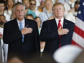 In this Saturday July 22, 2017 file photo, President Donald Trump, right, puts his hand over his heart with Virginia Gov. Terry McAuliffe during commissioning ceremonies aboard the nuclear aircraft carrier USS Gerald R. Ford at Naval Station Norfolk in Norfolk, Va.