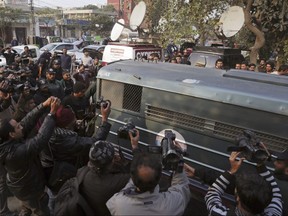 Surrounded by journalists and security forces, a prison van carrying Mohammad Imran, who is accused of the brutal killings of eight children in Kasur, arrives to a courthouse, in Lahore, Pakistan, Wednesday, Jan. 24, 2018.
