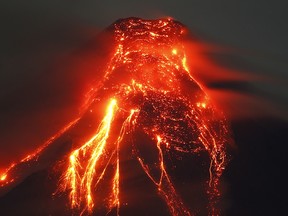 Mayon volcano spews molten lava during its sporadic eruption early Thursday, Jan. 25, 2018 as seen from a village in Legazpi city. (AP Photo/Bullit Marquez)