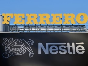 This combination of pictures created on January 10, 2018, shows the logo of Ferrero at the top of the Ferrero plant in Alba taken on May 17, 2014; and the logo of the world's leading food industry group Nestle taken on October 9, 2014 at the group's Research Center in Vers-chez-les-Blanc above Lausanne. (FABRICE COFFRINI/AFP/Getty Images)