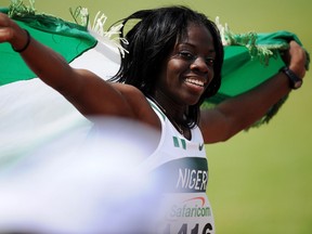 Seun Adigun of Nigeria celebrates with the Nigerian flag after crossing the finish line in first place in the Women's 100 meters Hurdles final during the five day 17th African Athletics Champioships in Nairobi, on July 29, 2010