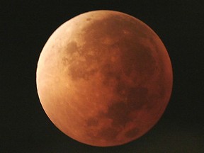 In this Aug. 28, 2007, file photo, the moon takes on different orange tones during a lunar eclipse seen from Mexico City. On Wednesday, Jan. 31, 2018, a super moon, blue moon and a lunar eclipse will coincide for the first time since 1982.
