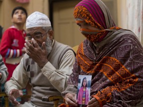 In this Thursday, Jan. 18, 2018 photo, Nusrat holds a photo of her daughter, Zainab Ansari, who was raped and killed, as her husband, Mohammed Amin in Kasur, sits beside her in Kasur, Pakistan.