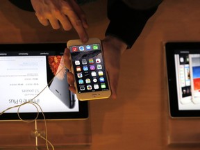 In this Sept.19, 2014 file photo, a customer checks the iPhone 6, in Paris. A French prosecutor office said Tuesday Jan.9, 2018 an investigation into Apple over alleged planned obsolescence of some of its smartphones has been opened. It follows a legal complaint filed in December by pro-consumer group Halte a l'obsolescence programmee (Stop Planned Obsolescence). Under a 2015 law, it is banned to intentionally shorten lifespan of a product in order to incite customers replace it.