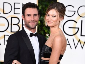 FILE - In this Jan. 11, 2015 file photo, Adam Levine, left, and Behati Prinsloo arrive at the 72nd annual Golden Globe Awards in Beverly Hills, Calif. A spokeswoman for "The Voice" coach says Levine and the Victoria's Secret model welcomed a daughter named Dusty Rose Levine. No other details were provided. The frontman for the band Maroon 5 and Prinsloo have been married since 2014.