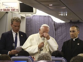 Pope Francis, flanked by father Mauricio Rueda, delegate for the organization of the papal journeys, right, and Greg Burke, spokesman of the Vatican, rubs his eyes as he arrives to talk with journalists during his flight from Lima, Peru, to Rome, Sunday, Jan. 21, 2018.