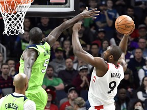 Minnesota Timberwolves' Gorgui Dieng, left, of Senegal, tries to block a shot by Toronto Raptors' Serge Ibaka in the first half of an NBA basketball game Saturday, Jan. 20, 2018, in Minneapolis. The Associated Press