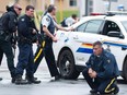 Police keep watch on a house as they search for a heavily armed gunman following the shooting of three Mounties in Moncton, N.B., on June 5, 2014.
