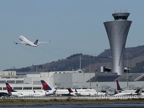 In this Oct. 24, 2017, file photo, the air traffic control tower is in sight as a plane takes off from San Francisco International Airport in San Francisco.