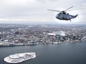 A CH-124 Sea King helicopter flies over the harbour in Halifax on Friday, Jan. 19, 2018. THE CANADIAN PRESS/Andrew Vaughan