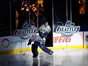 In this Jan. 9, 2018, photo, fans cheer at the ShoWare Center in Kent, Wash., about 20 miles south of Seattle, as Seattle Thunderbirds' Liam Hughes, left, and Nolan Volcan take the ice at the start of a Western Hockey League game