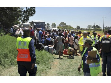 Train passengers are transferred to a bus at the scene of a train accident near Kroonstad, South Africa, Thursday, Jan 4, 2018.