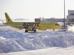A Spirit Airlines airplane prepares to drive around a large snow pile at Logan International Airport January 5, 2018 in Boston.