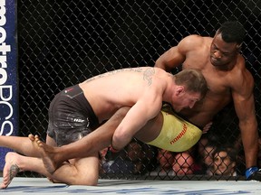 Stipe Miocic, left, takes down Francis Ngannou during a heavyweight championship mixed martial arts bout at UFC 220, early Sunday, Jan. 21, 2018, in Boston. (AP Photo/Gregory Payan)