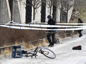 Swedish police search the area outside Varby Gard metro station, in Stockholm, near to where two people were injured by some kind of explosion, Sunday Jan. 7, 2018.  An unidentified explosive device is reported to have detonated Sunday.