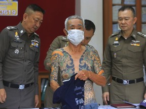 Japanese gang member Shigeharu Shirai displays his tattoos at a police station during a press conference in Lopburi, central Thailand, Thursday, Jan. 11, 2018.
