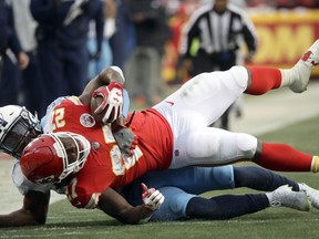 Kansas City Chiefs running back Kareem Hunt (27) is tackled by Tennessee Titans safety Kevin Byard (31) in Kansas City, Mo., Saturday, Jan. 6, 2018.