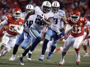 Tennessee Titans running back Derrick Henry (22) runs for a 35-yard touchdown away from Kansas City Chiefs linebacker Kevin Pierre-Louis (57) and linebacker Tamba Hali (91) during the second half of an NFL wild-card playoff football game in Kansas City, Mo., Saturday, Jan. 6, 2018.