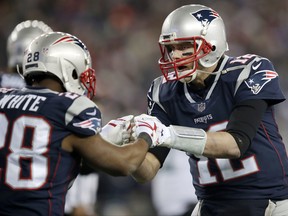 Patriots quarterback Tom Brady (12) celebrates a touchdown by running back James White (28) during the second half of the AFC Championship Game against the Jaguars in Foxborough, Mass., Sunday, Jan. 21, 2018.