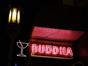 In this photo taken Thursday, Dec. 21, 2017, a neon sign shines above the Buddha Lounge bar on Chinatown's Grant Avenue in San Francisco. The bar, a dinky, quirky dive is known for betting on your drink in a game of Liar's Dice between you and the bartender.