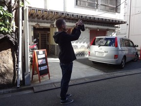 This Nov. 12, 2017 photo shows tour guide Lee Chapman taking a photo on a photowalk tour in Tokyo. (Linda Lombardi via AP)