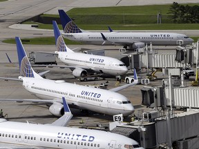 In this July 8, 2015, file photo, United Airlines planes are parked at their gates as another plane, top, taxis past them at George Bush Intercontinental Airport in Houston.