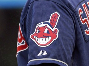 In this April 8, 2014 photo, the Cleveland Indians Chief Wahoo logo is shown on the uniform sleeve of third base coach Mike Sarbaugh during a baseball game against the San Diego Padres in Cleveland, Ohio