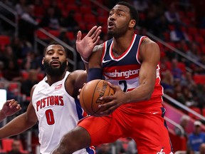 John Wall of the Washington Wizards tries to get a shot off around Andre Drummond of the Detroit Pistons during the second half at Little Caesars Arena on Jan. 19, 2018