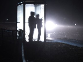 Storm watchers take cover in a bus shelter to watch waves in Eastern Passage, N.S. on Thursday, Jan. 4, 2018. Tens of thousands of people were waking up in the dark this morning after a ferocious storm blasted through Atlantic Canada, flooding coastal roads, battering sailboats and downing trees with hurricane-force winds.