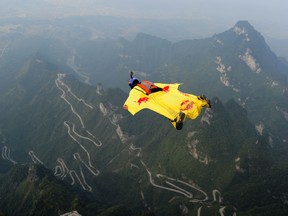 A participant jumps off a platform for a wingsuit flight from Tianmen Mountain in Zhangjiajie, China on Oct. 18, 2015.